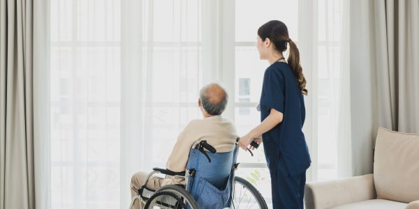 Senior man in wheelchair receives medical help for injury