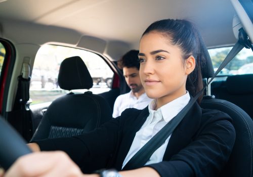 Taxi driver with passenger at back seat.