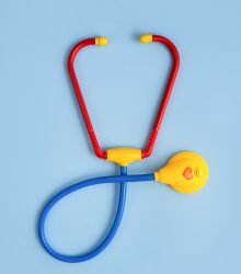 Toy stethoscope on a blue background. Children's medicine. Pediatrics. Doctor game.